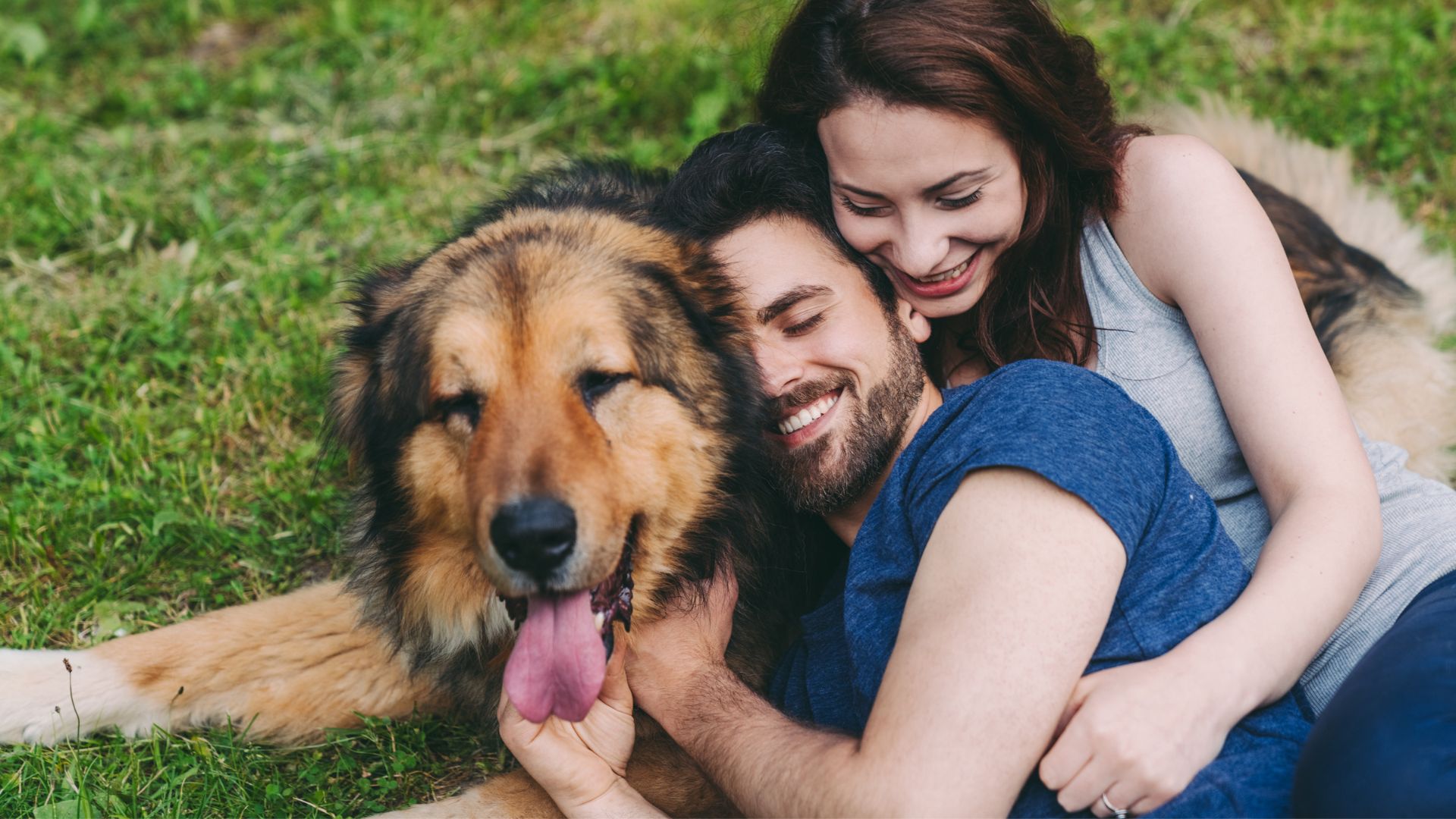 Dog owners hugging their dog